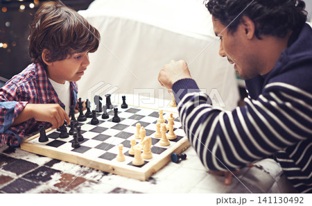 Father, child and chess board game for competition challenge for planning strategy with pawn, knight or queen. Man, son and thinking choice for moving piece for winning play, holiday or connection Father, child and chess board game for competition challenge for planning strategy with pawn, knight or queen. Man, son and thinking choice for moving piece for winning play, holiday or connection 141130492