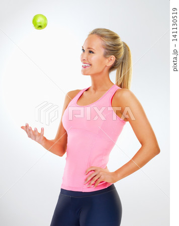 Woman, apple and wellness in studio for vitamins, nutrition and play with fruit on white background. Female person, happy and organic snack or vegan diet for wellbeing, balance and minerals in fiber 141130519