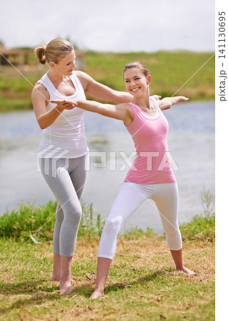 Women, yoga class and help with exercise outdoor for health, wellness and healing with coach. Fitness, pilates and stretching muscle for workout in park or garden, personal trainer and balance Women, yoga class and help with exercise outdoor for health, wellness and healing with coach. Fitness, pilates and stretching muscle for workout in park or garden, personal trainer and balance 141130695