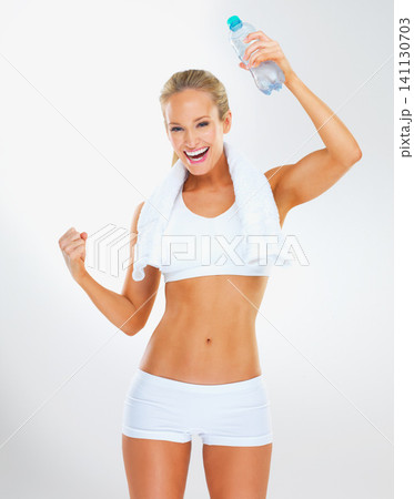 Woman, body and cheers with water for fitness, health and wellness in portrait, hydration and workout with towel at gym. Excited, celebration and fist pump for exercise with drink on white background Woman, body and cheers with water for fitness, health and wellness in portrait, hydration and workout with towel at gym. Excited, celebration and fist pump for exercise with drink on white background 141130703