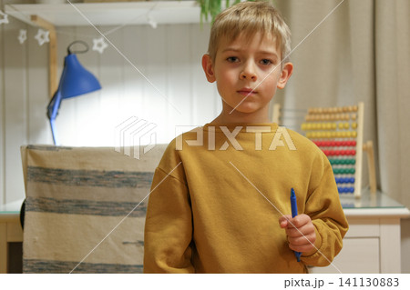 Preschooler engaged with colorful abacus in peaceful room. Boy carefully counts with abacus in comfortable room environment. Young Preschool kid practicing counting concentrates on number practice Preschooler engaged with colorful abacus in peaceful room. Boy carefully counts with abacus in comfortable room environment. Young Preschool kid practicing counting concentrates on number practice 141130883