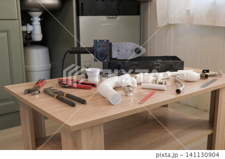Plumber workplace desk. Ready to repairing sink, pipe wrench in hand, fixing faucet, water piping sanitary tools, water supply. No people, nobody. Plumbing service. Checklist in house for building Plumber workplace desk. Ready to repairing sink, pipe wrench in hand, fixing faucet, water piping sanitary tools, water supply. No people, nobody. Plumbing service. Checklist in house for building 141130904