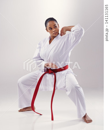 Woman, training and karate fighter in studio, fitness and martial arts on white background. Black person, athlete and red belt for taekwondo, discipline and warrior ready for self defense or battle 141131165