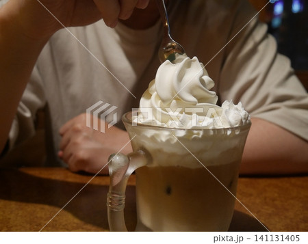 ソフトクリームがのったカフェオレを飲む男性(顔なし) ソフトクリームがのったカフェオレを飲む男性(顔なし) 141131405