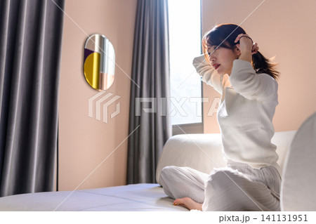 部屋で髪を結ぶ女性 部屋で髪を結ぶ女性 141131951