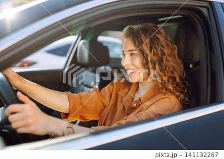 Emotional woman drives a car. The concept of fast movement, traveling by car. Emotional woman drives a car. The concept of fast movement, traveling by car. 141132267