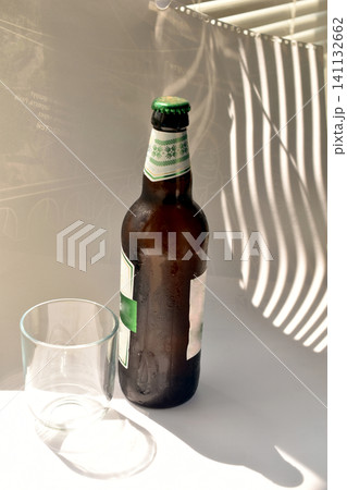A bottle of light beer and a glass. 141132662