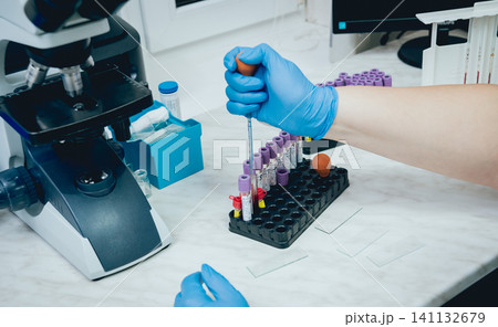 Laboratory assistant conducts a blood test. Laboratory assistant conducts a blood test. 141132679