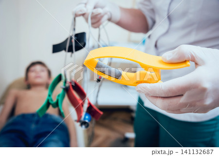 Doctor with electrocardiogram equipment making cardiogram test 141132687