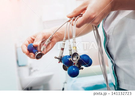 Doctor with electrocardiogram equipment making cardiogram test 141132723