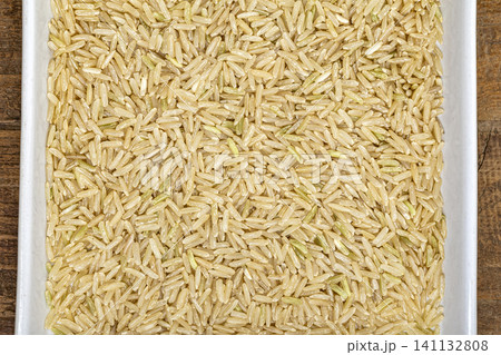 Hom Mali brown rice and white rice grains close-up in a bowl, showing natural color variation and long kernels of jasmine rice for food, cooking, and nutrition concepts Hom Mali brown rice and white rice grains close-up in a bowl, showing natural color variation and long kernels of jasmine rice for food, cooking, and nutrition concepts 141132808