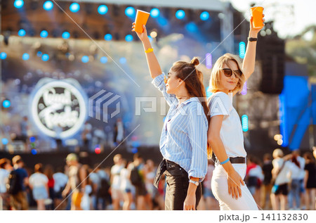Two woman having great time at music festival. Girlfriends rinking beer at Beach party. Lifestyle. Two woman having great time at music festival. Girlfriends rinking beer at Beach party. Lifestyle. 141132830