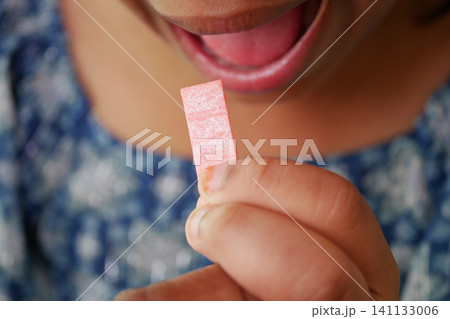 A child holding a pink stick of bubble gum A child holding a pink stick of bubble gum 141133006
