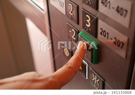 Pressing the elevator button in a bustling building Pressing the elevator button in a bustling building 141133008