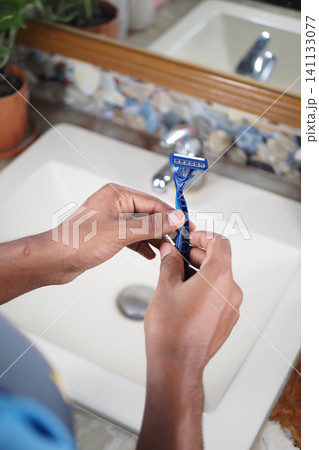 Preparing to shave with a new razor in a cozy bathroom Preparing to shave with a new razor in a cozy bathroom 141133077