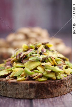 Close-Up Pile of Sliced Shelled Pistachios on Rustic Wooden Board for Baking and Garnish Close-Up Pile of Sliced Shelled Pistachios on Rustic Wooden Board for Baking and Garnish 141133091