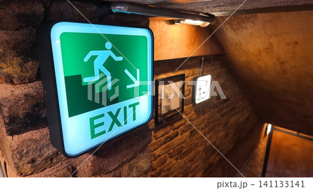 Bright exit sign guiding the way in a cozy underground space Bright exit sign guiding the way in a cozy underground space 141133141
