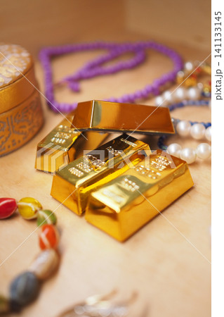 Golden treasures surrounded by colorful beads and jewelry 141133145