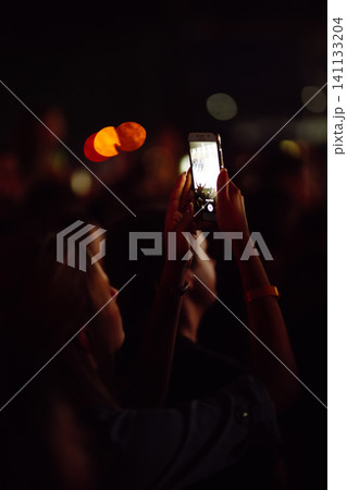 Hand with smartphone records live music festival, Taking photo of concert stage, live concert. Hand with smartphone records live music festival, Taking photo of concert stage, live concert. 141133204
