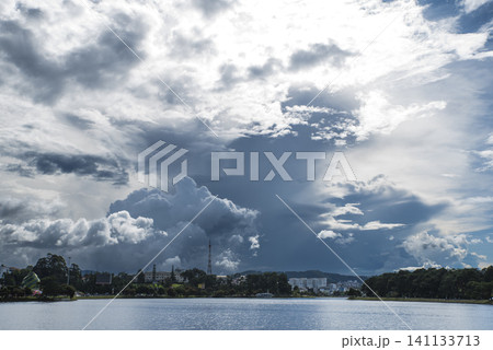 A large cloud is in the sky above a body of water 141133713