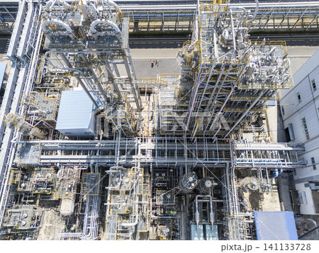 High-angle drone shot of complex pipelines and steel structures in a massive petrochemical plant and industrial complex. High-angle drone shot of complex pipelines and steel structures in a massive petrochemical plant and industrial complex. 141133728