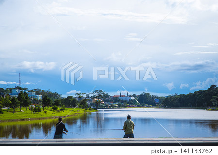 Two men are fishing in a lake 141133762