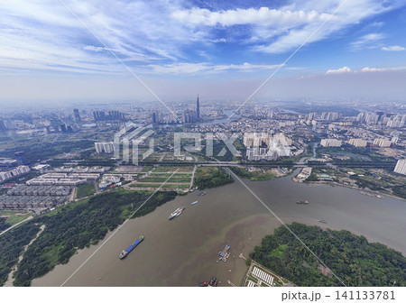 Panoramic aerial drone view of the Saigon River and the modern city skyline with Landmark 81 under a blue sky in Ho Chi Minh City, Vietnam. Panoramic aerial drone view of the Saigon River and the modern city skyline with Landmark 81 under a blue sky in Ho Chi Minh City, Vietnam. 141133781