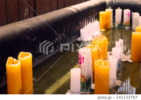Rows of lit yellow and white prayer candles burning at a Korean Buddhist temple Rows of lit yellow and white prayer candles burning at a Korean Buddhist temple 141133787