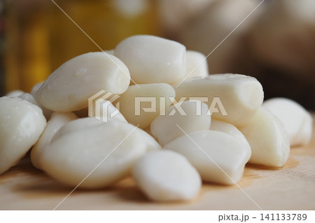 Chopped garlic cloves placed on a wooden surface 141133789