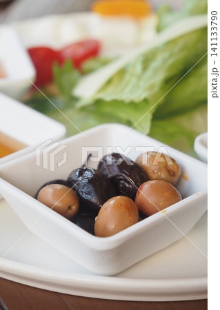 Variety of olives served on a white plate in a restaurant Variety of olives served on a white plate in a restaurant 141133790