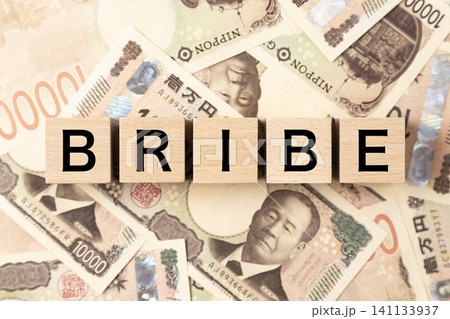 「BRIBE」と書かれたブロックとたくさんの一万円札 「BRIBE」と書かれたブロックとたくさんの一万円札 141133937