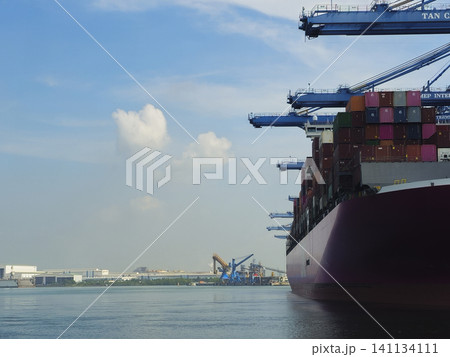 A large red ship is in the water near a port A large red ship is in the water near a port 141134111