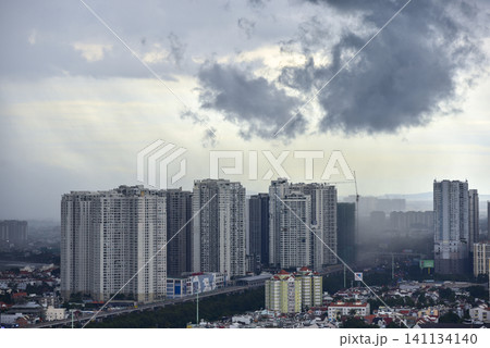 High-rise apartment buildings under dark storm clouds and a passing rain shower in the city High-rise apartment buildings under dark storm clouds and a passing rain shower in the city 141134140