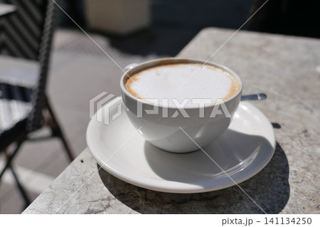 Enjoying coffee on a sunny day at a cafe Enjoying coffee on a sunny day at a cafe 141134250