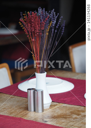 Vase with dried flowers on a dining table setting Vase with dried flowers on a dining table setting 141134268