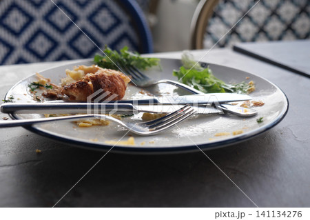 Dishes with remnants of a meal on a cafe table Dishes with remnants of a meal on a cafe table 141134276