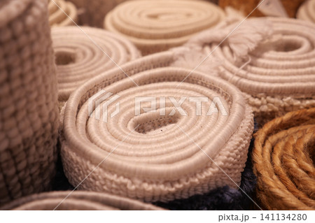 Coiled textile rolls displayed at a market stall 141134280