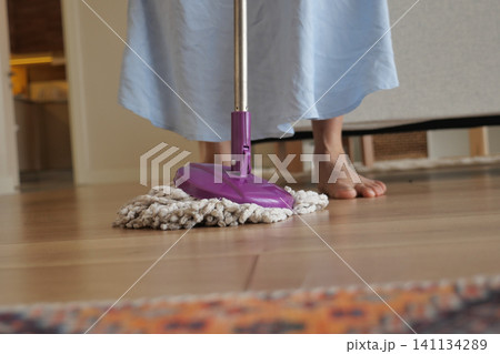 Cleaning wooden floors with a mop at home Cleaning wooden floors with a mop at home 141134289