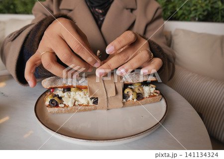 Hands preparing food at a restaurant table in the afternoon Hands preparing food at a restaurant table in the afternoon 141134324