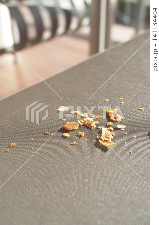 Crumbs scattered on a table during a sunny afternoon Crumbs scattered on a table during a sunny afternoon 141134404