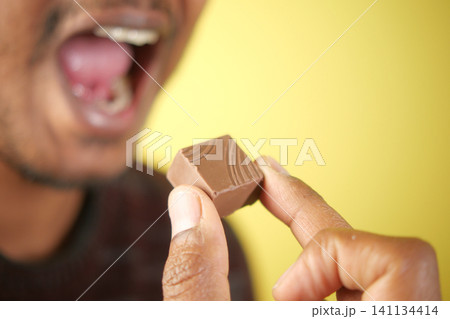 Enjoying a chocolate treat with a joyful expression Enjoying a chocolate treat with a joyful expression 141134414