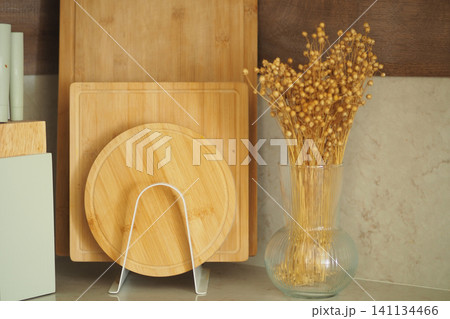 Natural kitchen decor with wooden cutting boards and flowers Natural kitchen decor with wooden cutting boards and flowers 141134466