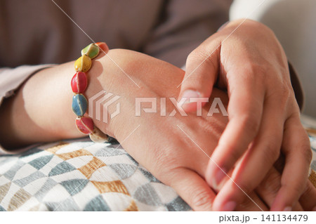 Colorful bracelet worn by a person resting at home Colorful bracelet worn by a person resting at home 141134479