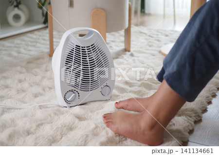 Warm air gently blows on feet during a cozy indoor moment Warm air gently blows on feet during a cozy indoor moment 141134661
