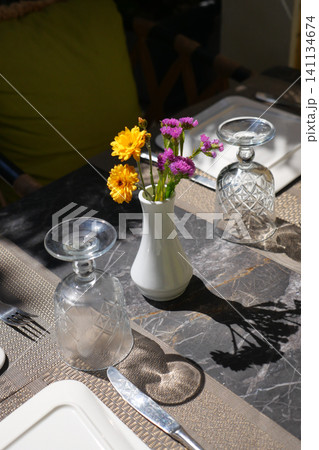 Beautifully arranged dining table with floral centerpiece Beautifully arranged dining table with floral centerpiece 141134674