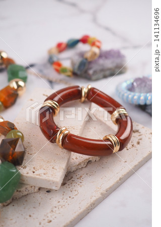 Colorful jewelry on a textured surface with stones 141134696