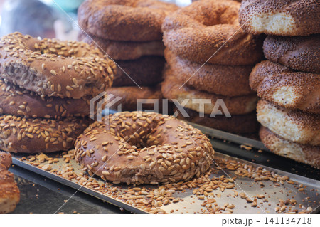 Freshly baked bagels with seeds on a display table 141134718