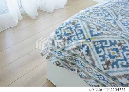 Cozy bedroom with patterned bedding and natural light Cozy bedroom with patterned bedding and natural light 141134722