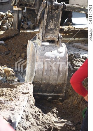 Excavator working on construction site in urban area Excavator working on construction site in urban area 141134761