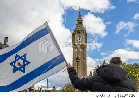 Person holding an Israeli flag near Big Ben in London Person holding an Israeli flag near Big Ben in London 141134826